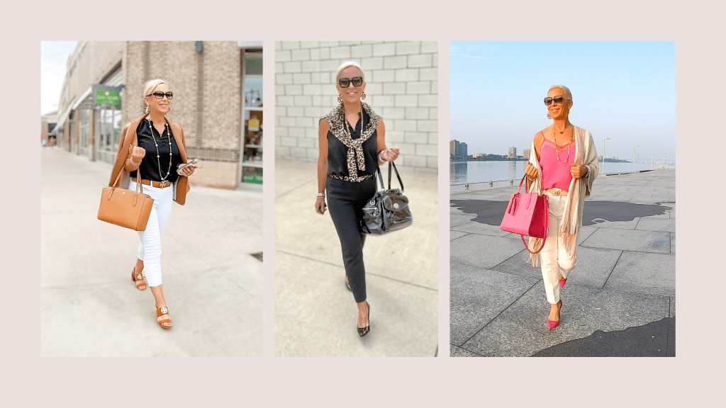 Three stylish women over 50 walking outdoors, showcasing different summer outfits. The left features a woman in a black top and white pants with a brown handbag. The middle woman wears a black top with a scarf and black pants, holding a black bag. The right woman is in a pink top paired with white pants, carrying a pink tote.