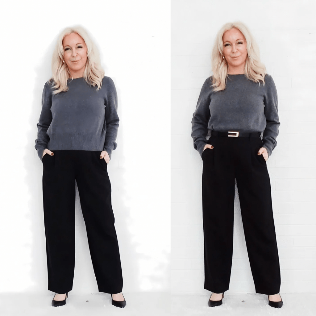 A woman with long blonde hair wearing a gray sweater and black pants, posing with hands in pockets against a white background.