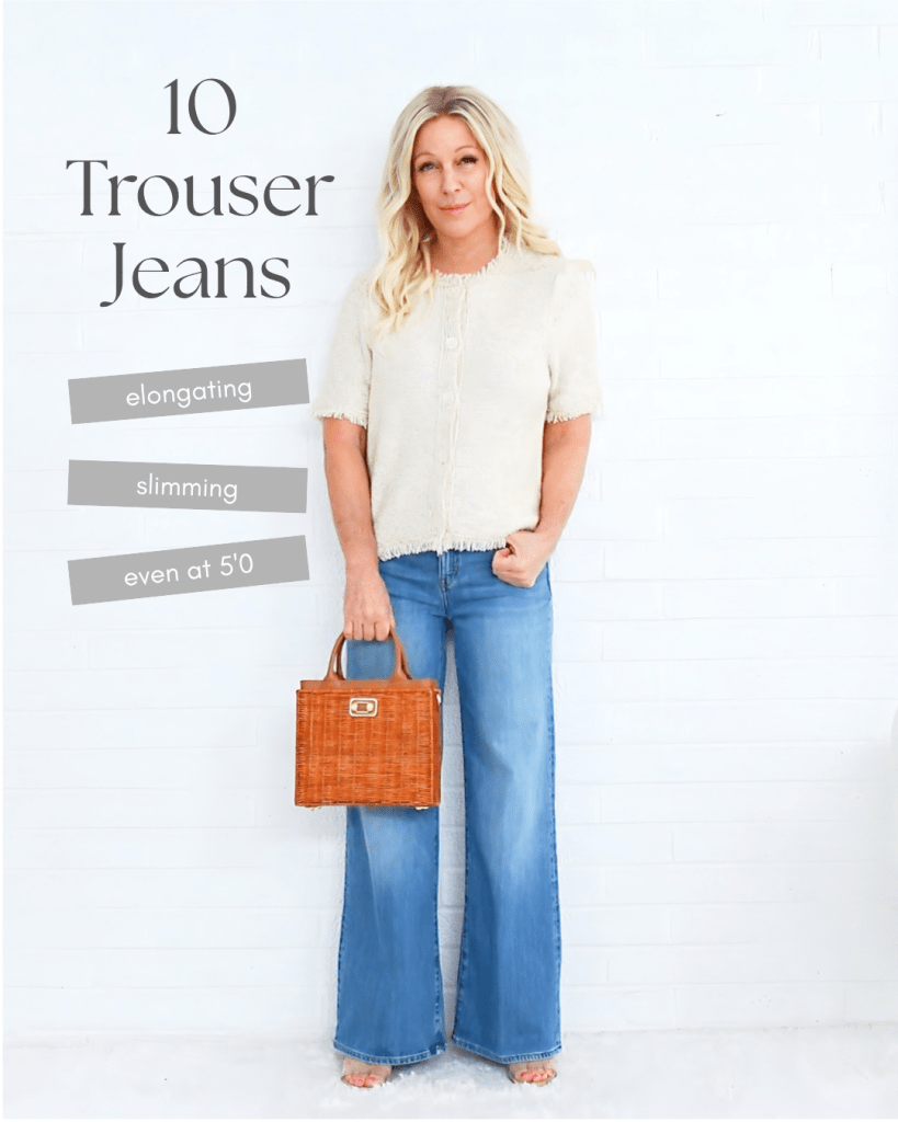 A woman standing in front of a white wall, wearing a beige button-up top and blue trouser jeans, holding a small brown woven handbag. Text overlay includes '10 Trouser Jeans' and three descriptive phrases: 'elongating', 'slimming', and 'even at 5'0'.