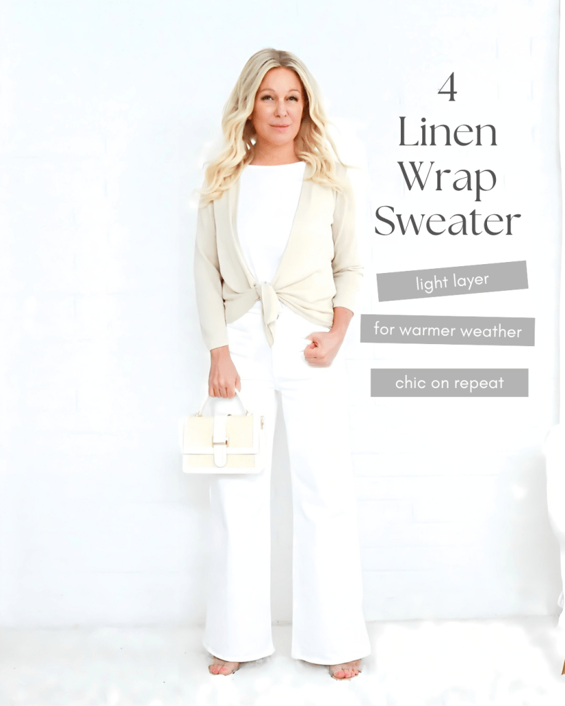 A woman standing against a white background, wearing a light beige linen wrap sweater tied at the waist, paired with white wide-leg trousers. She holds a small white handbag and smiles at the camera. Text on the image highlights it as a chic light layer for warmer weather.